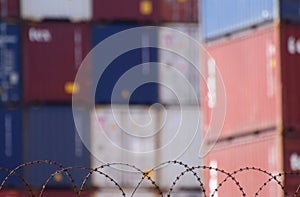 Freight shipping containers behind barbed wire