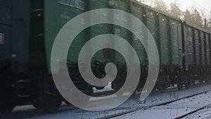 A freight train arrives at the station on a sunny winter day.