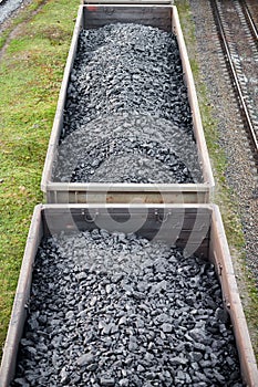 Freight train with cargo cars transporting coal, wood, fuel