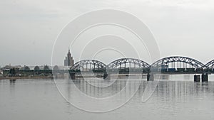 Freight train crossing railway bridge and entering the city of Riga