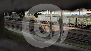 Freight train, locomotive and wagons are traveling by rail. View through hole.