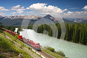 Freight train moving along Bow river in Canadian R