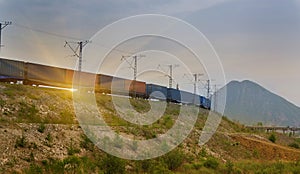 Freight train passing by on sunset