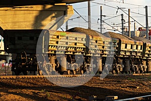 Freight train on rails. Wagons with delivery of ore, crushed stone, coal by railway
