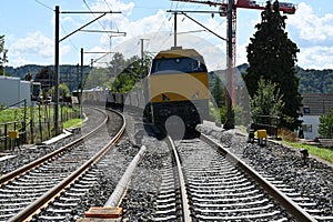 A freight train with railway carriages viewed from forward.