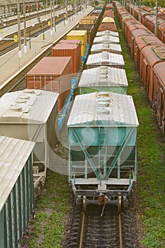 Freight train with tank wagons moving in forest. Green diesel cargo locomotive.
