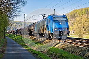 Freight train with tank wagons on the road through the city of Stadt Wehlen in Germany