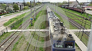 A freight train with wagons is moving along the track. Ukrainian railway