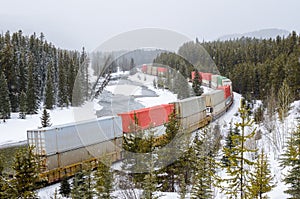 Freight TrainRunning Alongside a River During a Heavy Snowfall