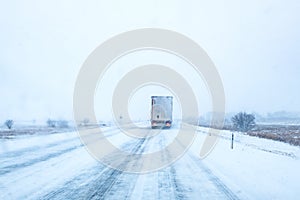 Freight transportation truck on the road in snow storm blizzard