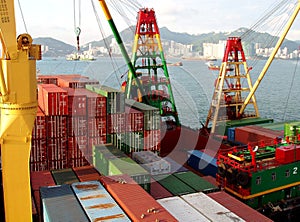 Freight vessel loading unloading in port terminal. Container ship with cranes in dock.