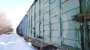 Freight wooden wagons of freight train at railway station in winter. Soviet style freight trains