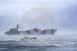 A freighter and a pilot boat in a powerful winter storm.