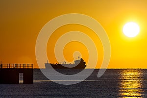 Freighter ship sailing at sunset photo