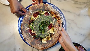 Freinds hands taking slice of pizza top view party food