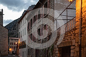 French alley with typical facade houses of Villefranche de Conflent at sunset.