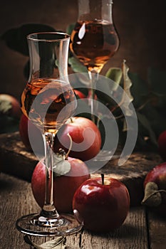 French apple strong alcoholic drink, still life in rustic style, vintage wooden background, selective focus