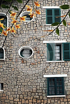 French architecture of ancient stone house with green wooden window and door at Da Lat