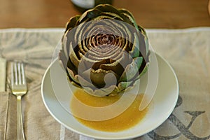 French artichoke on a plate with vinaigrette