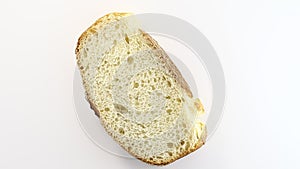 French baguette cut off piece rotation, turning counterclockwise, on white background, top view.