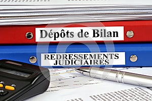 French bankruptcy and receivership files stacked on a desk in close-up photo