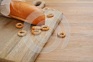 French bread and bagels on cutting board on wooden table