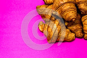 French breakfast concept. Close up of delicious, fresh croissants isolated on pink board