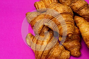 French breakfast concept. Close up of delicious, fresh croissants isolated on pink board