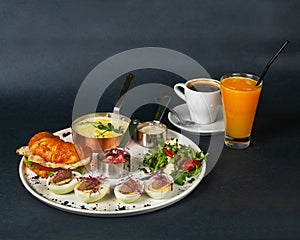 French breakfast - corn porridge, croissant with sliced chicken, rucola, tomato and cheese salad with pesto sauce, boiled chicken