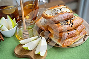 French brioche bun with pear, honey and tea on wooden table