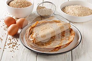 French buckwheat galettes pancakes on a plate with ingredients on a table. Horizontal photo