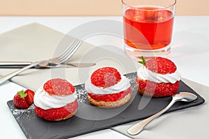 French Cakes with strawberry cream shanti. aery brewing cake on black shale. Restaurant composition on white background.