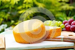 French cheeses collection, yellow Riche de Saveurs and Le peche des bons peres cheeses served on white marble plate outdoor in