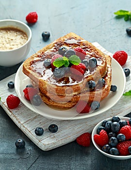 French cinnamon toast with blueberries, raspberries, maple syrup and coffee. morning breakfast