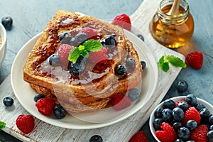 French cinnamon toast with blueberries, raspberries, maple syrup and coffee. morning breakfast