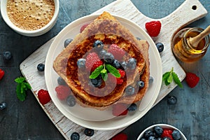 French cinnamon toast with blueberries, raspberries, maple syrup and coffee. morning breakfast