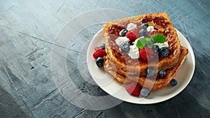 French cinnamon toast with blueberries, raspberries, maple syrup and coffee. morning breakfast