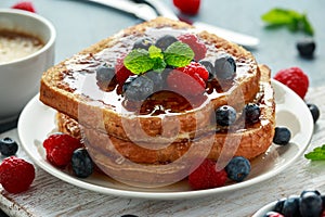 French cinnamon toast with blueberries, raspberries, maple syrup and coffee. morning breakfast