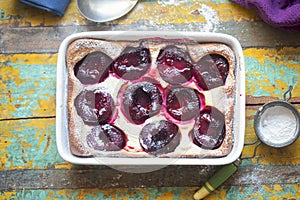 French clafoutis with plums and icing sugar