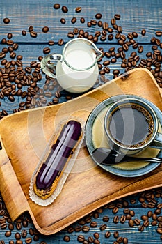 French coffee with cream and Eclair and coffee beans