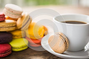 French colorful macarons with cup of coffee casual