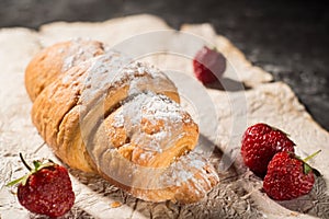 French croissant with strawberries. Rustic style, dark gray abstract background