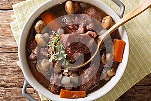 French cuisine: Coq au vin in wine close-up in a bowl. hori