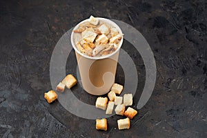 French cuisine hot food delivery - Close-up of mushroom soup with chicken meat in disposable paper cups on a dark stone