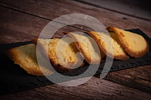 French delicacy pastry tuile with almond on wood background