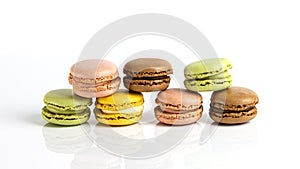 French dessert for coffee. alined multicolored macarons on white background