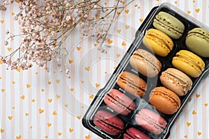 french dessert macarons of different colours on a romantic background with hearts and dry flowers