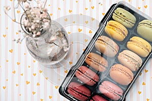 french dessert macarons of different colours on a romantic background with hearts and dry flowers