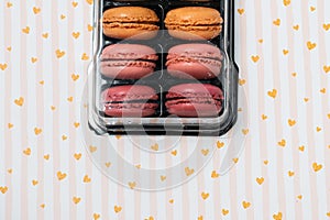 french dessert macarons of different colours on a romantic background with hearts and dry flowers