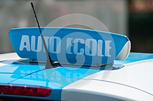 french driving school panel on the car roof , text in french